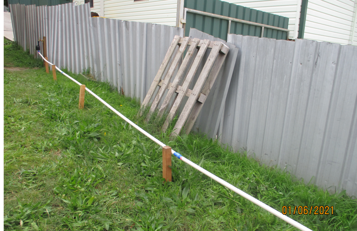 noisy-fence-sheet-with-pallet-leaning-against-it.png